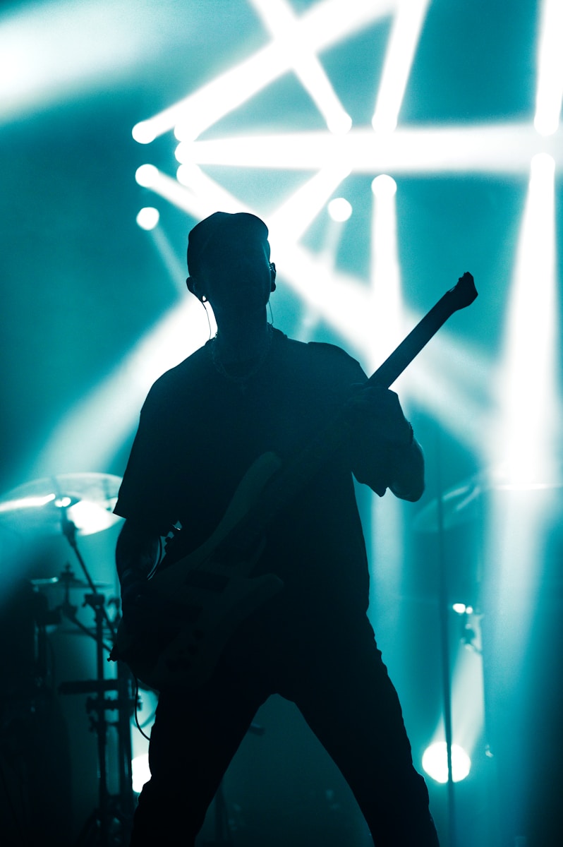 A man standing on a stage with a guitar